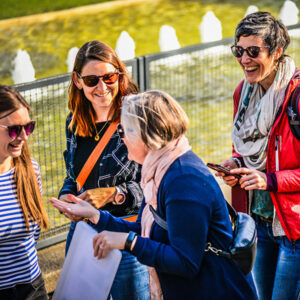 Das Bild zeigt eine Gruppe, die einen Krimi-Trail spielt und dabei lacht.